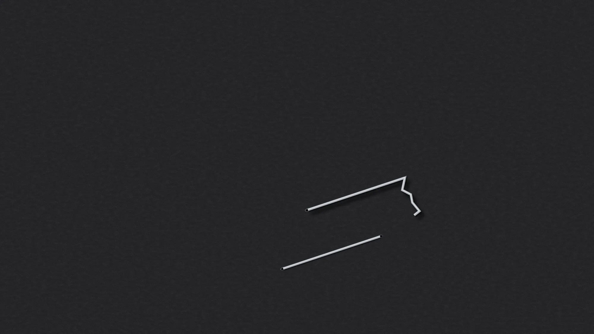 Misfire: A staple that went wrong on black card: one leg punched through, the other crumpled flat across the surface. Just below it sits the second attempt, perfectly flat.